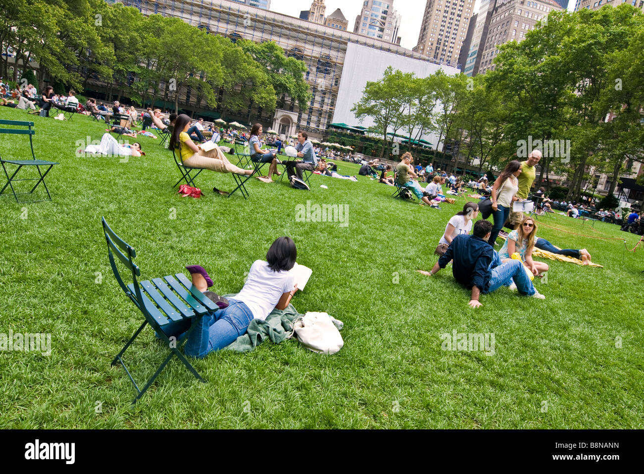 People sitting on chairs and relaxing on the lawn in a public garden Stock Photo