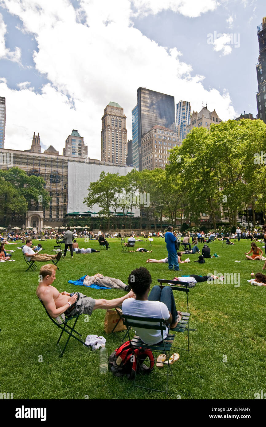 People sitting on chairs and relaxing on the lawn in a public garden Stock Photo