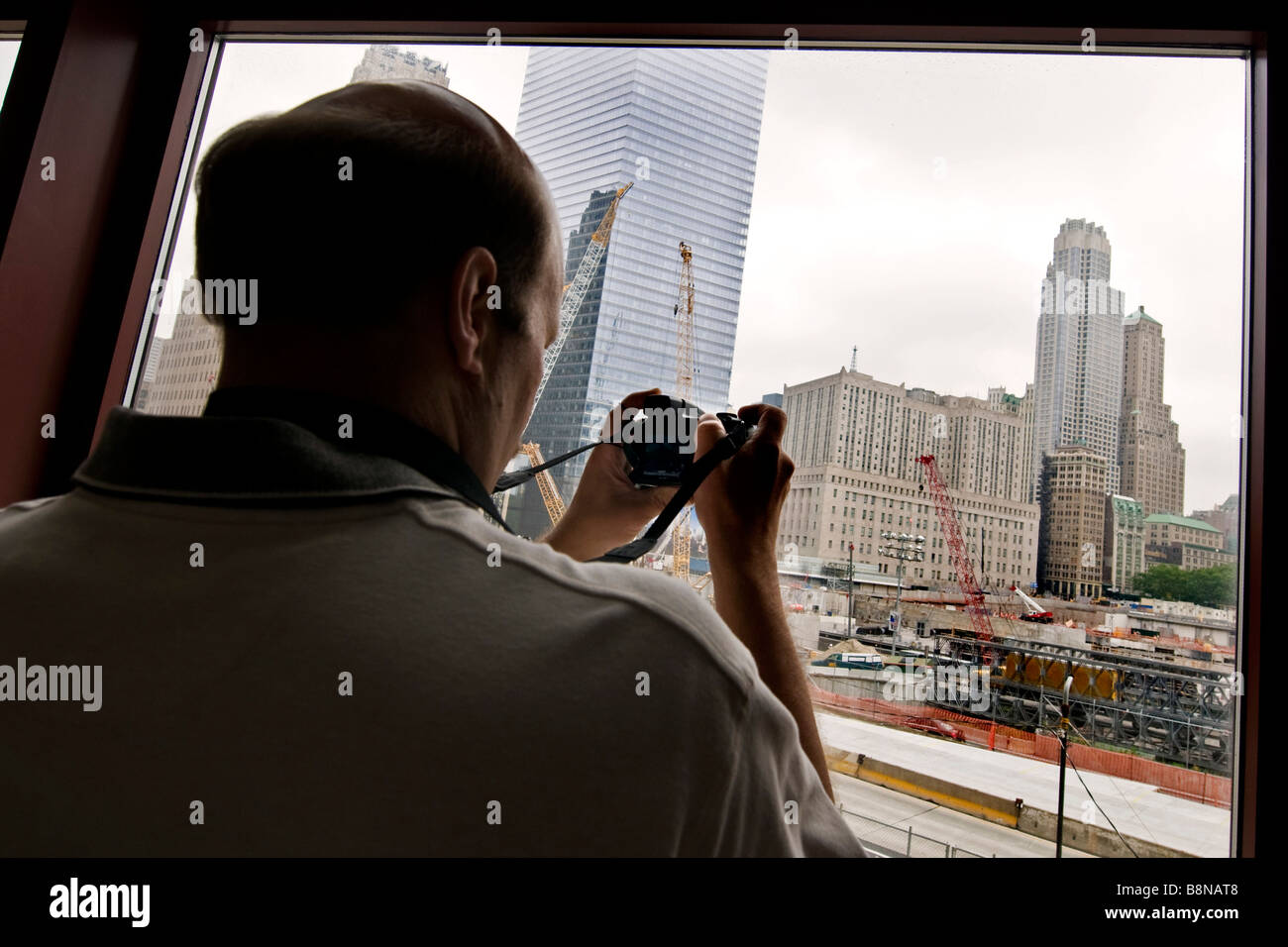 Tourist taking photographs of ground zero through a window Stock Photo