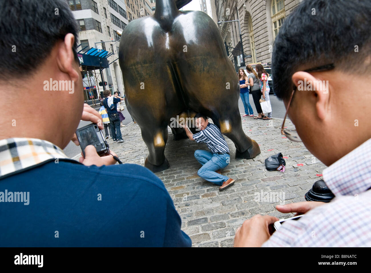 Tourists photographing the bronze Charging Bull in downtown New York city Stock Photo