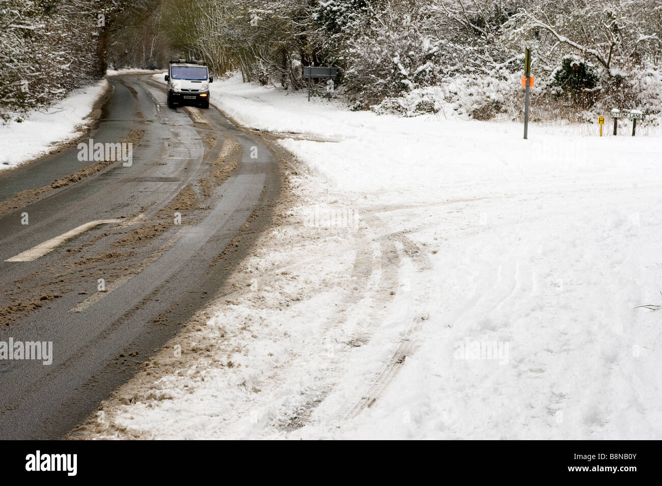 A car driving in a snow covered rural country road in a UK Winter Stock Photo
