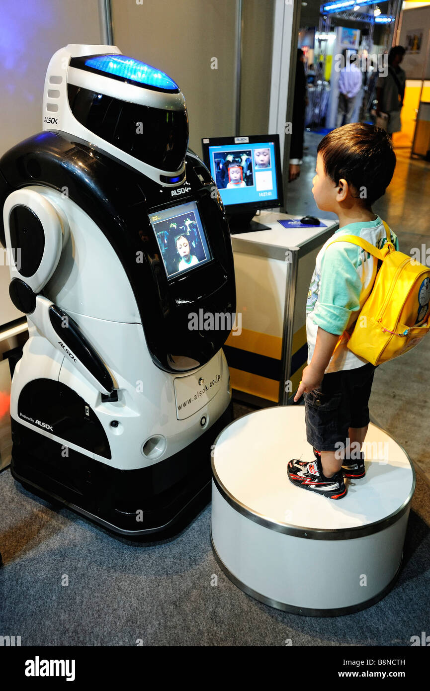 A young visitor looks at Sohgo Security Services ALSOK's security robot Reborg-Q in Yokohama, Japan. Stock Photo