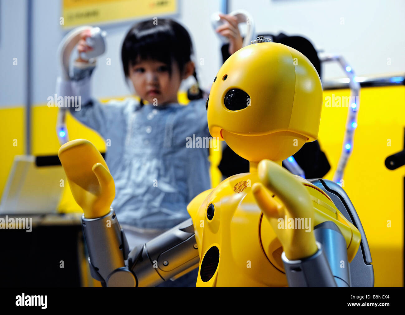 A young visitor wears a flexible sensor tube FST body suit to remotely control Mitsubishi Heavy