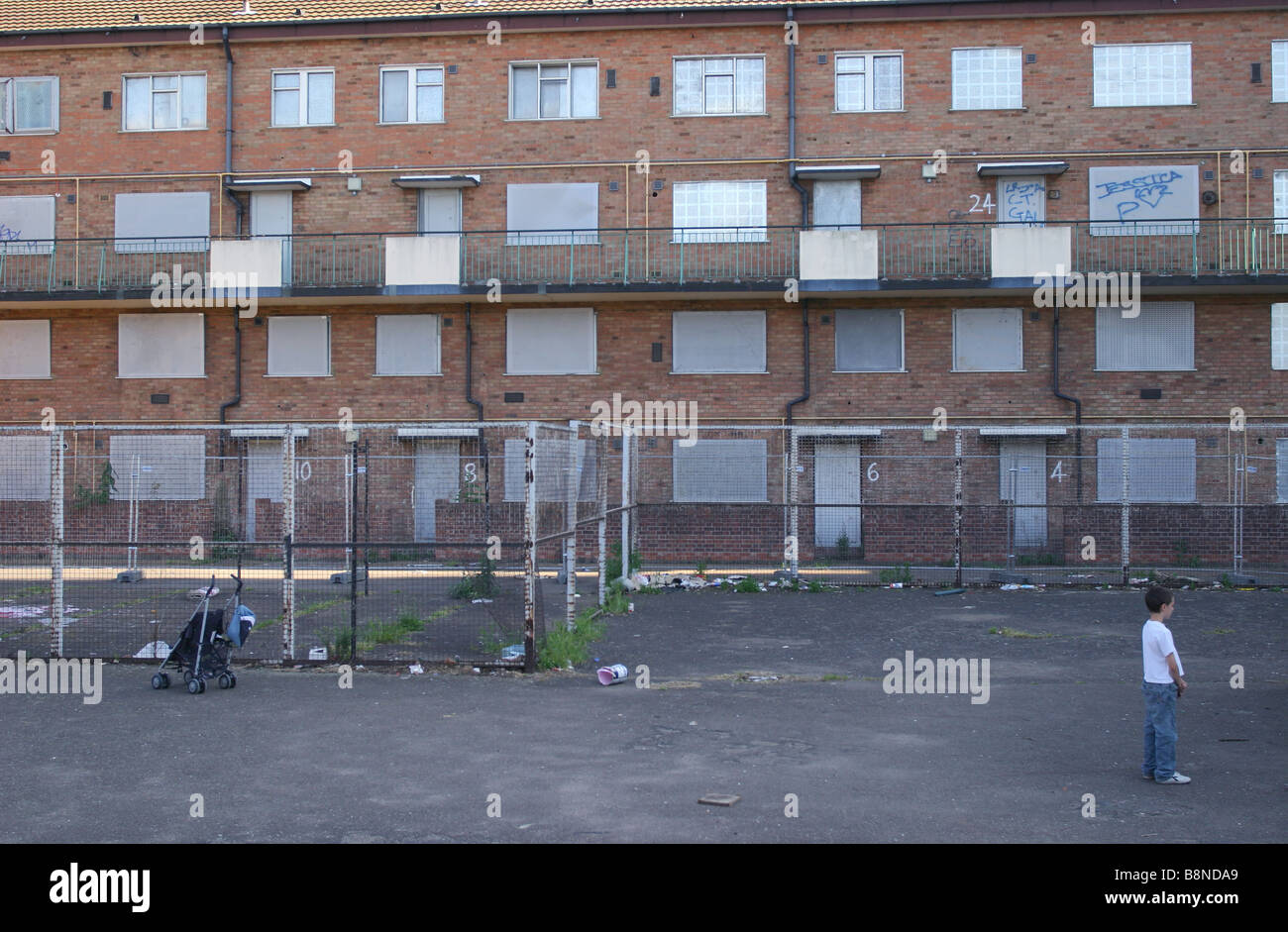 A child standing next to derelict flats whilst playing outside. Stock Photo