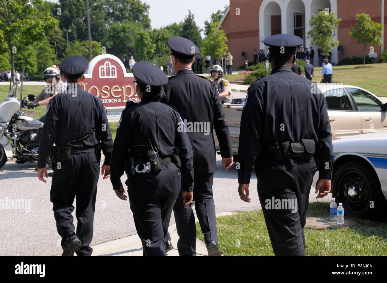 Four police officers walking down the street Stock Photo
