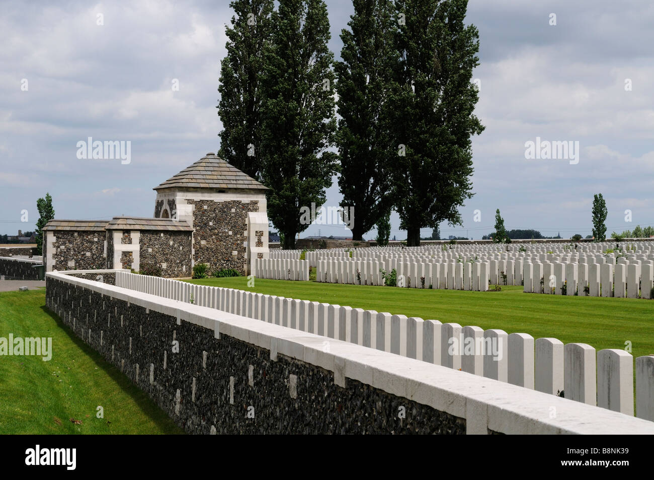 Rows of headstones lined up against the outside wall of Tyne Cot Cemetery Stock Photo