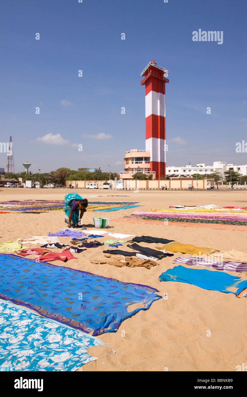 India Tamil Nadu Chennai woman drying colourful laundry on beach below the lighthouse Stock Photo