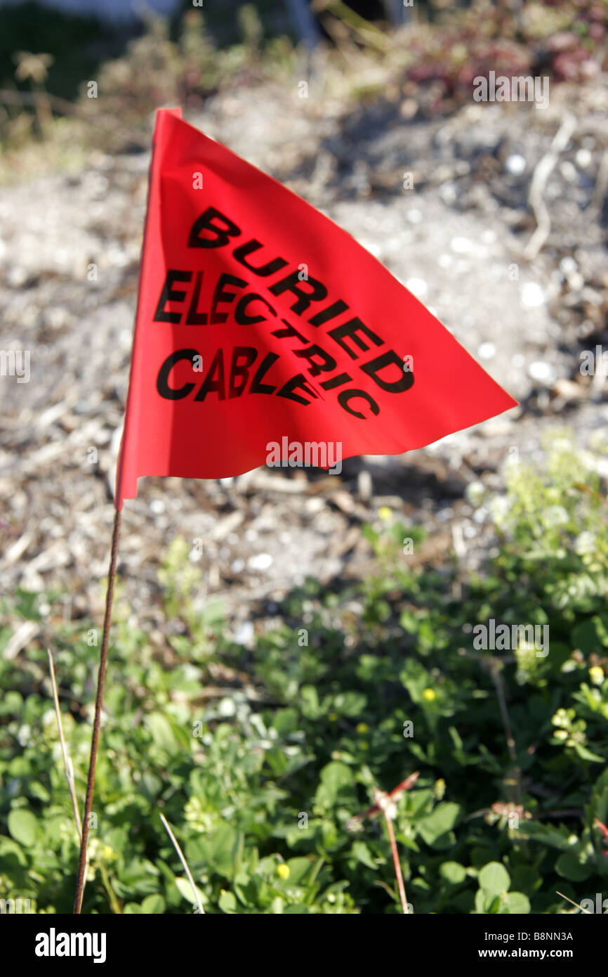 Buried electric cable warning flag Stock Photo