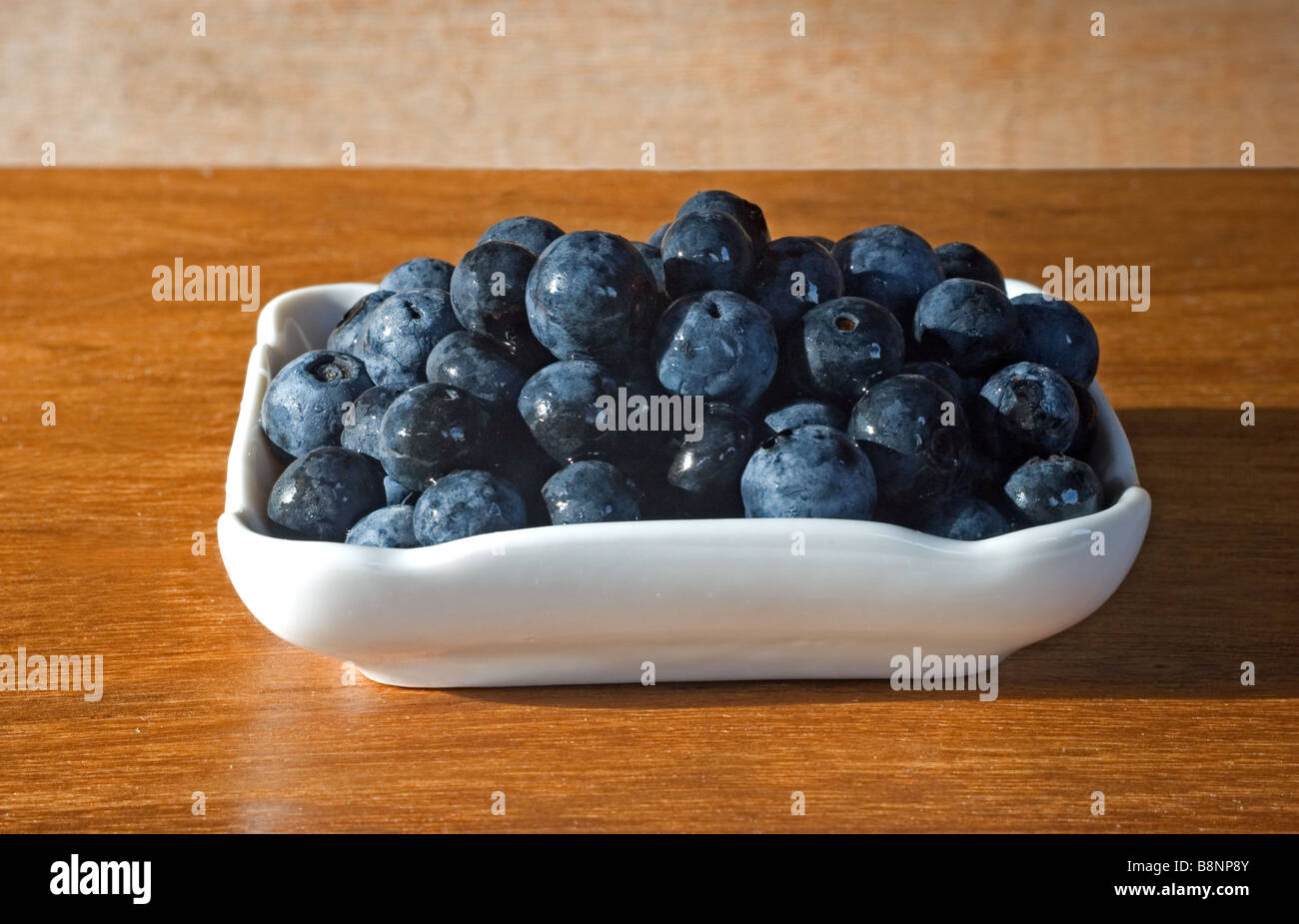 Blueberries in a dish on wooden table Stock Photo