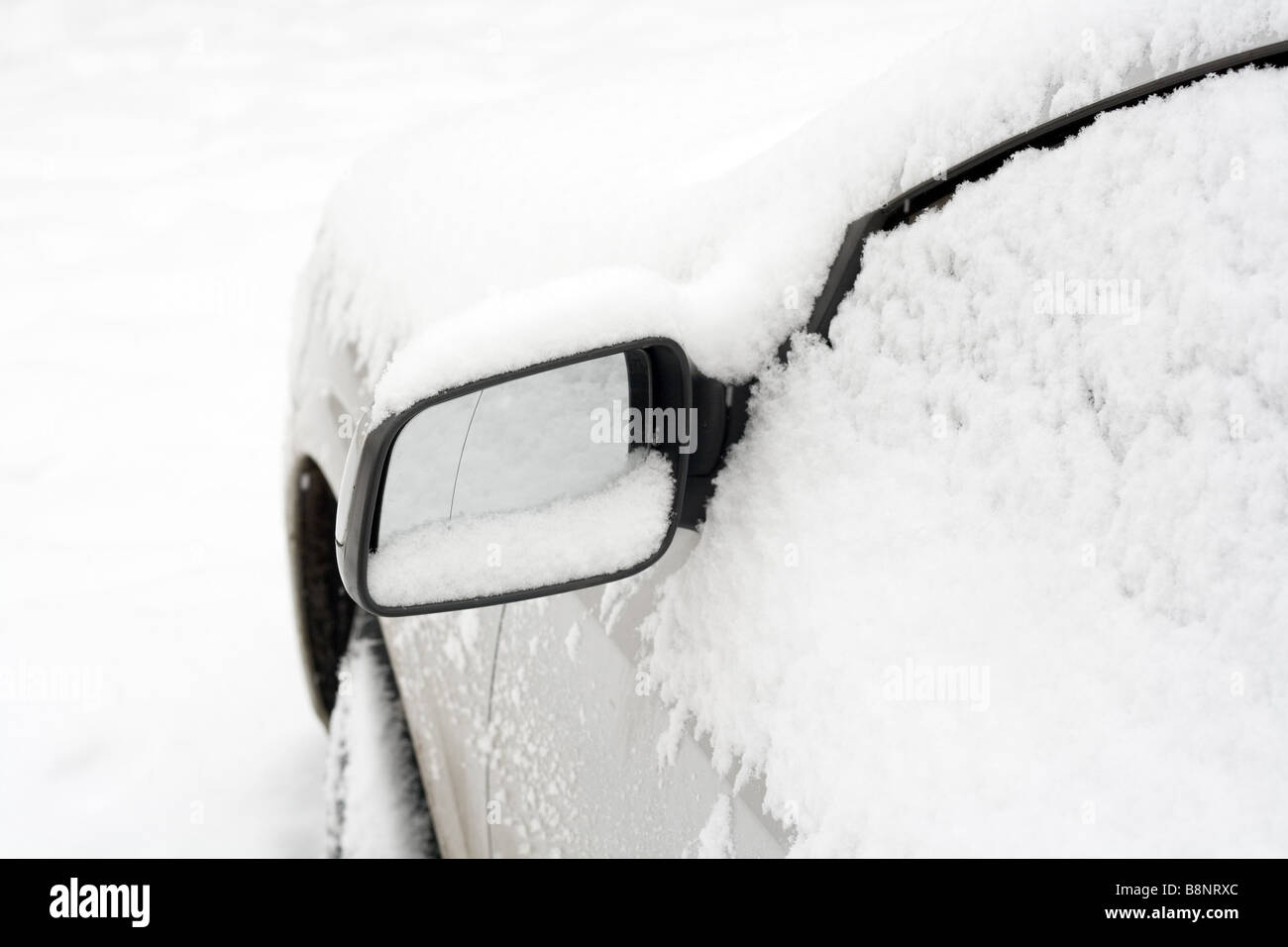 Close up of mirror of snow covered car Stock Photo
