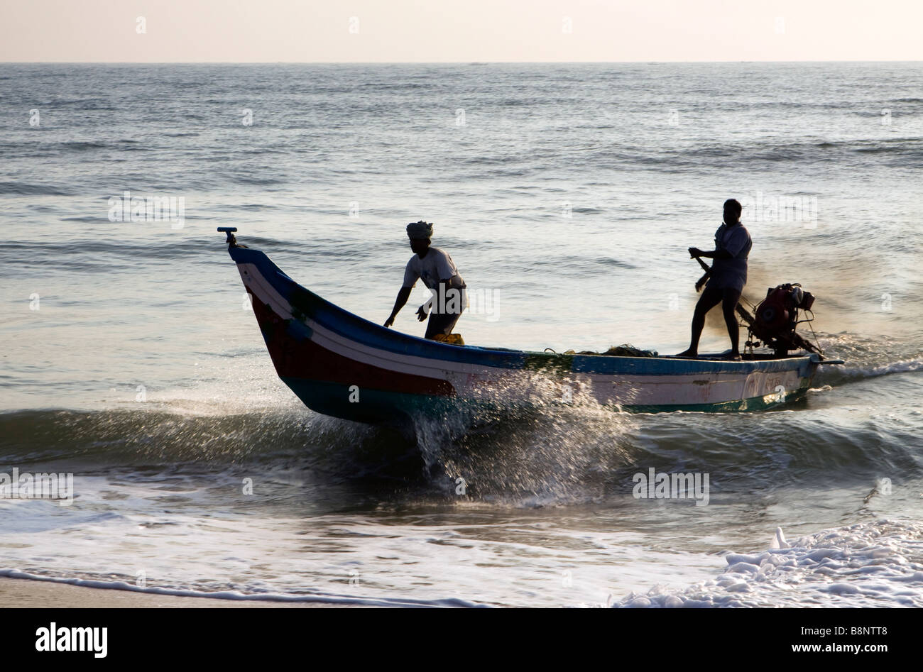 India Tamil Nadu Mamallapuram fishing village fishermen returning to shore in tsunami relief boat Stock Photo