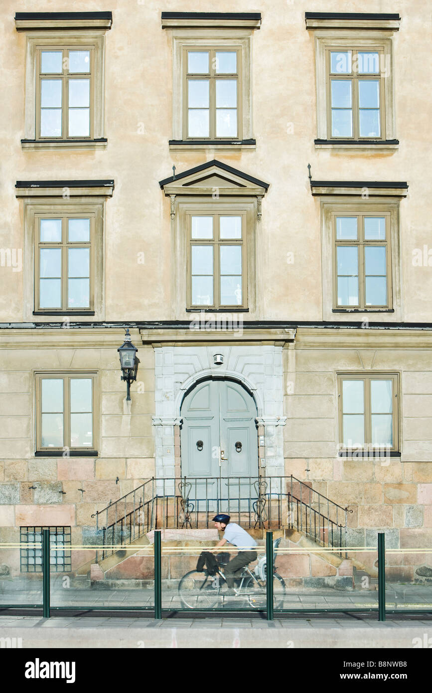 Sweden, Stockholm, bicyclist riding in front of apartment building Stock Photo