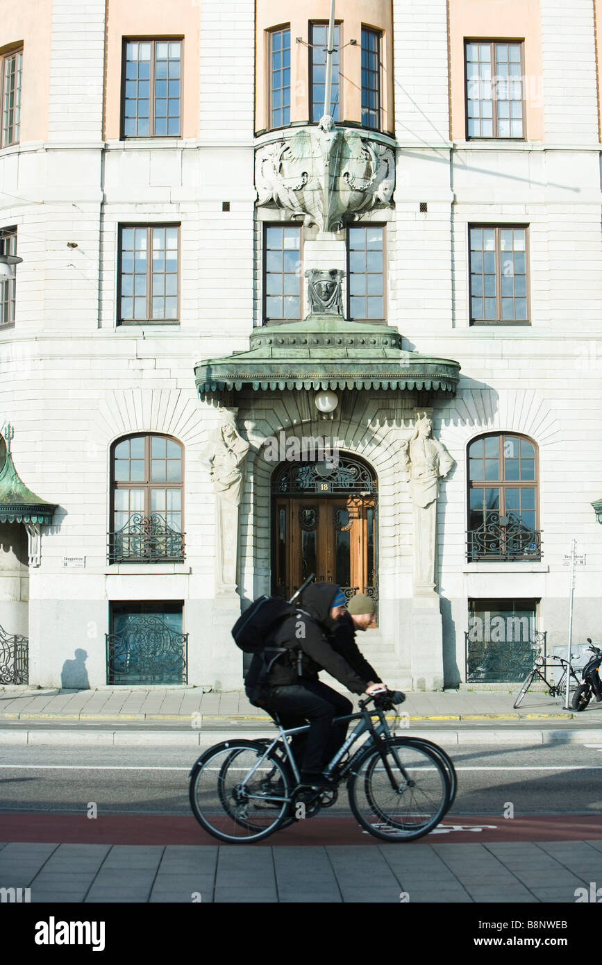 Sweden, Stockholm, bicyclists riding past ornate building Stock Photo