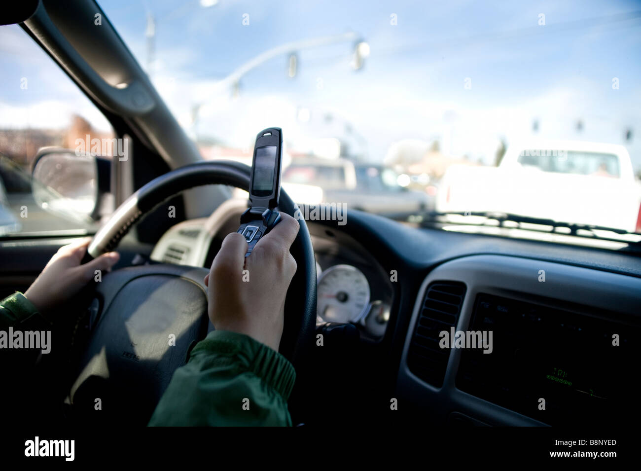 Person texting on a cell phone while driving a car Stock Photo