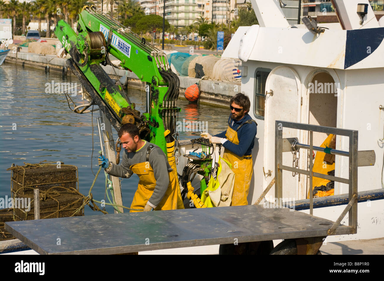 Commercial Fishing Boat Crew fishermen Unloading Their Oyster Catch With a Hydraulic Winch At