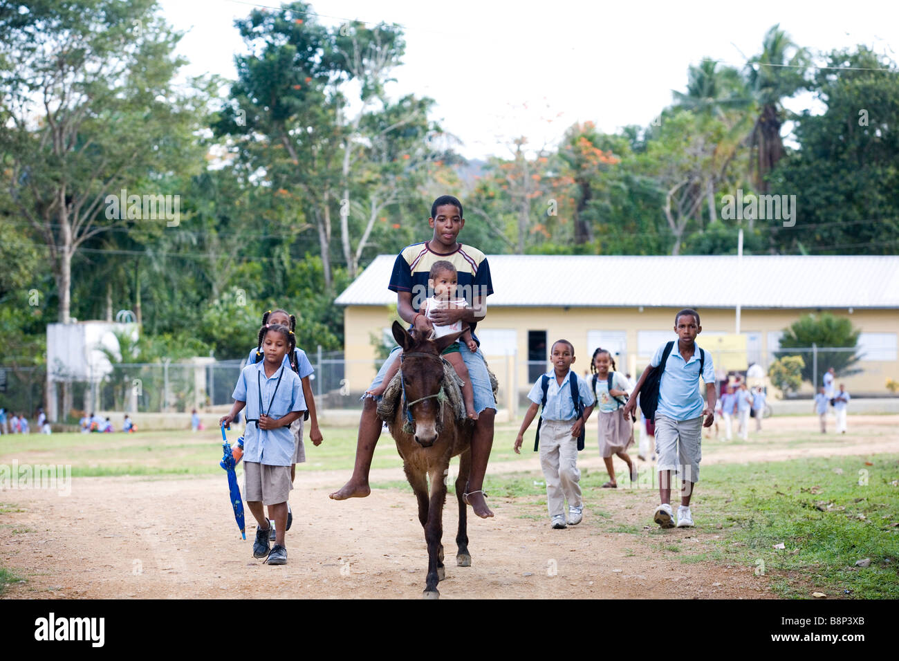 Young man with boy on horseback riding, Dominican Republic Stock Photo
