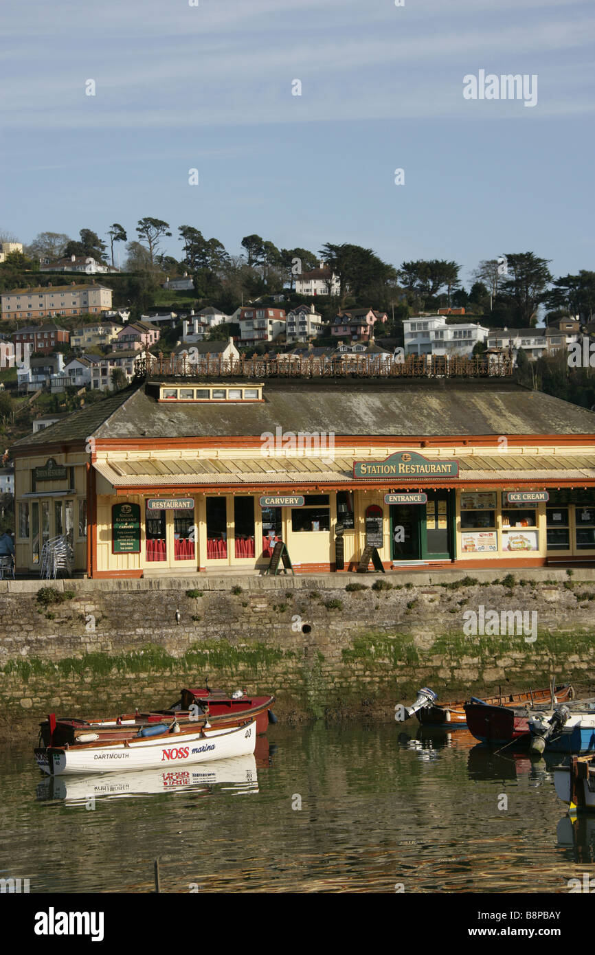 Town of Dartmouth, England. Station Restaurant on Dartmouth’s North Embankment with the town of Kingswear in the background. Stock Photo