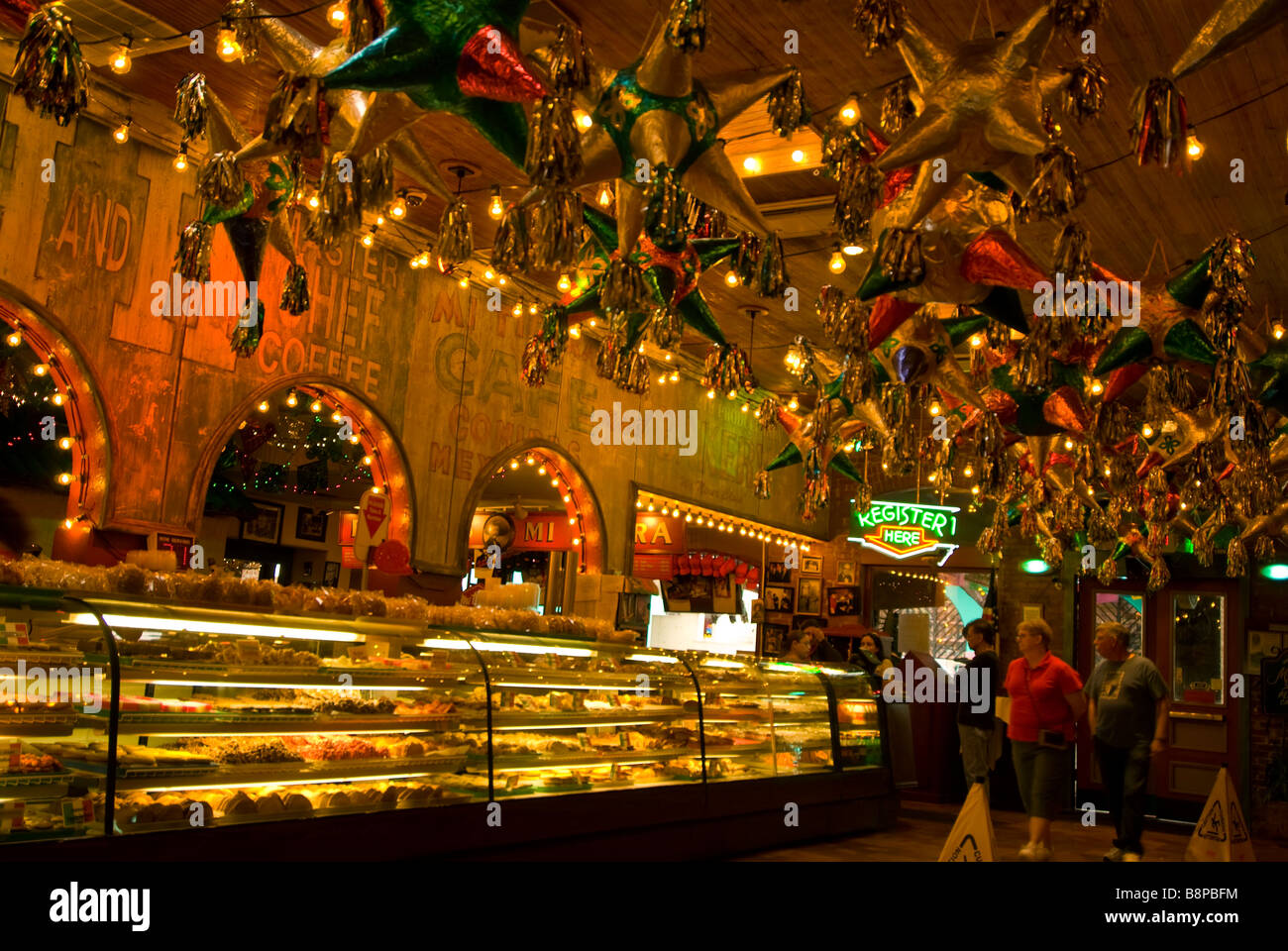 Mi Tierra Bakery baked goods counter with customers and display with overhead decor mexican pinatas San Antonio Texas tx landmark Stock Photo