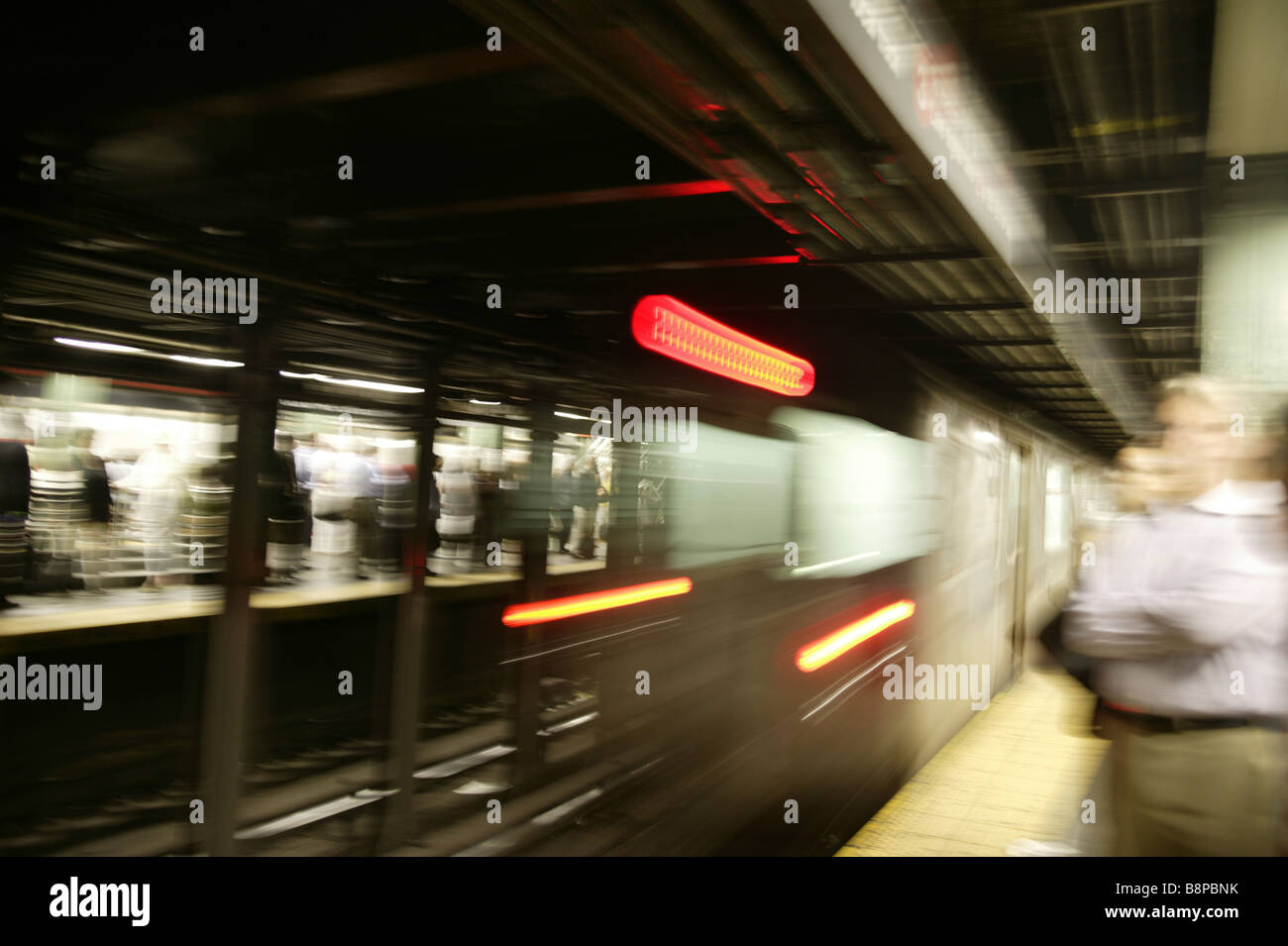 NYC subway train speeding out of Station Stock Photo