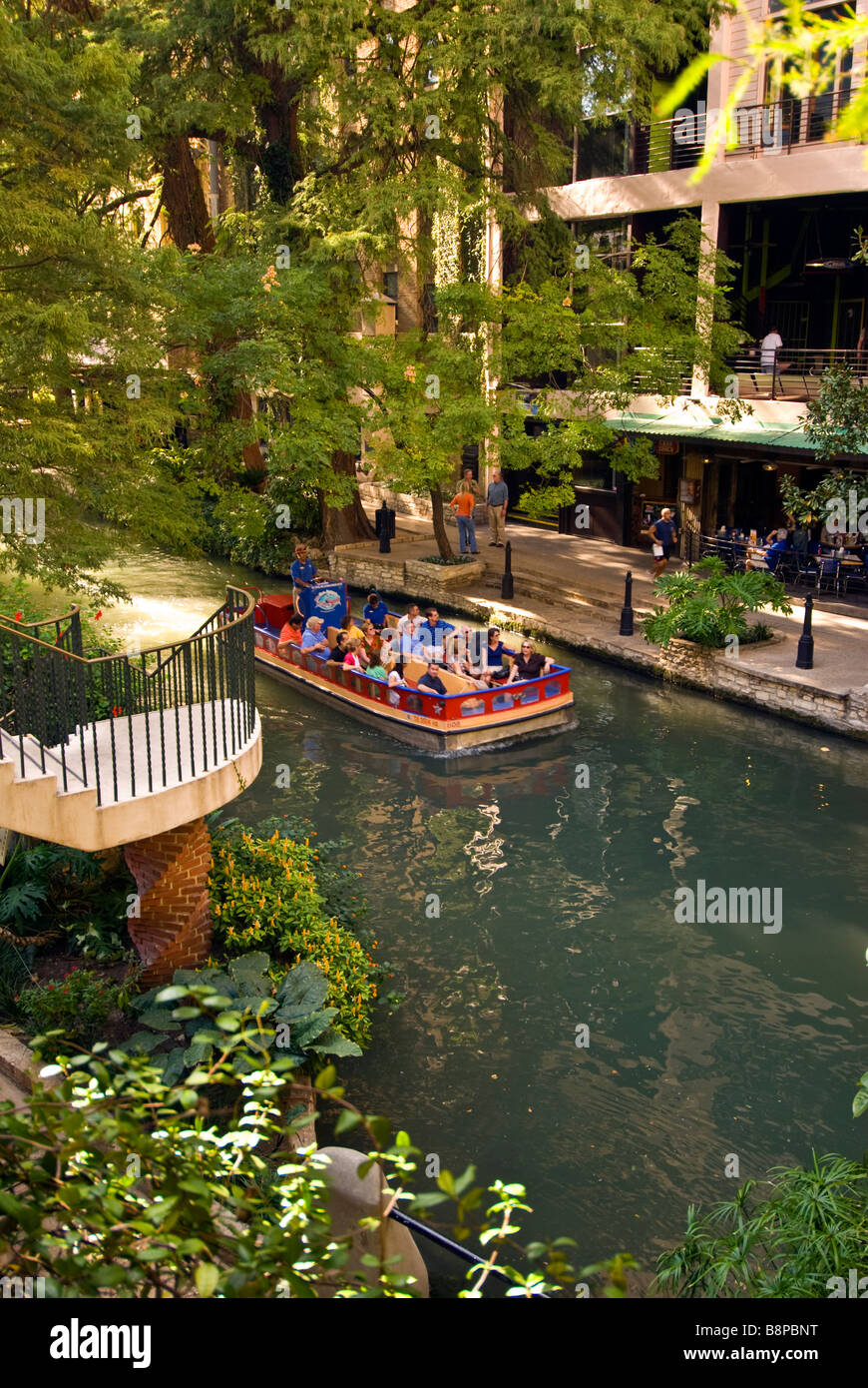 San Antonio River Walk riverwalk tour boat with tourists passes beside