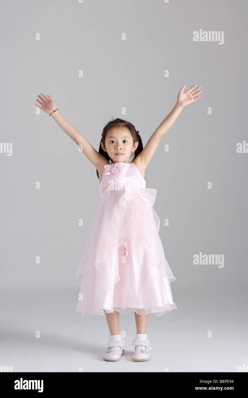 Girl wearing dress with arms raised portrait Stock Photo