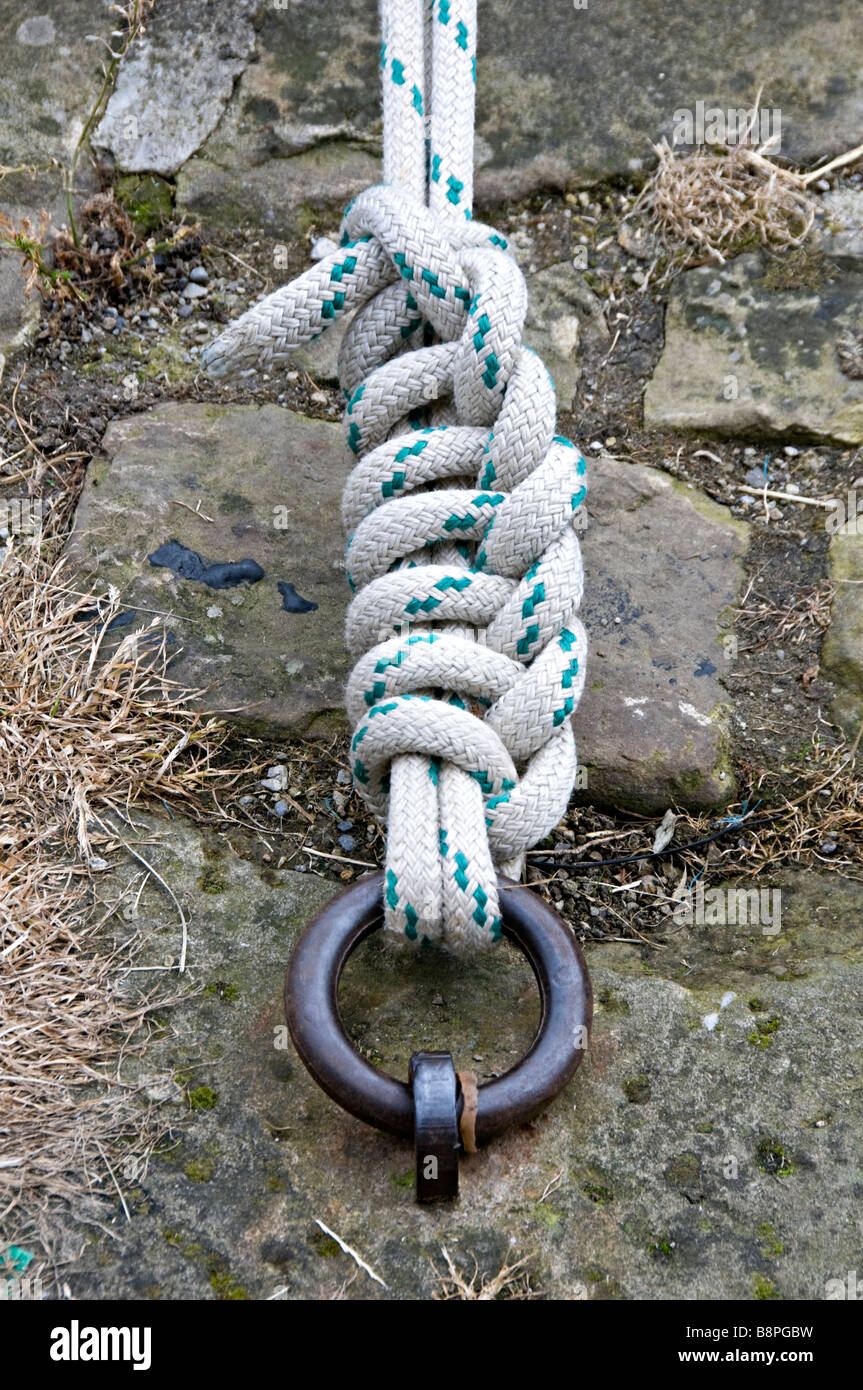 Mooring line tied to iron ring on the side of a canal Stock Photo