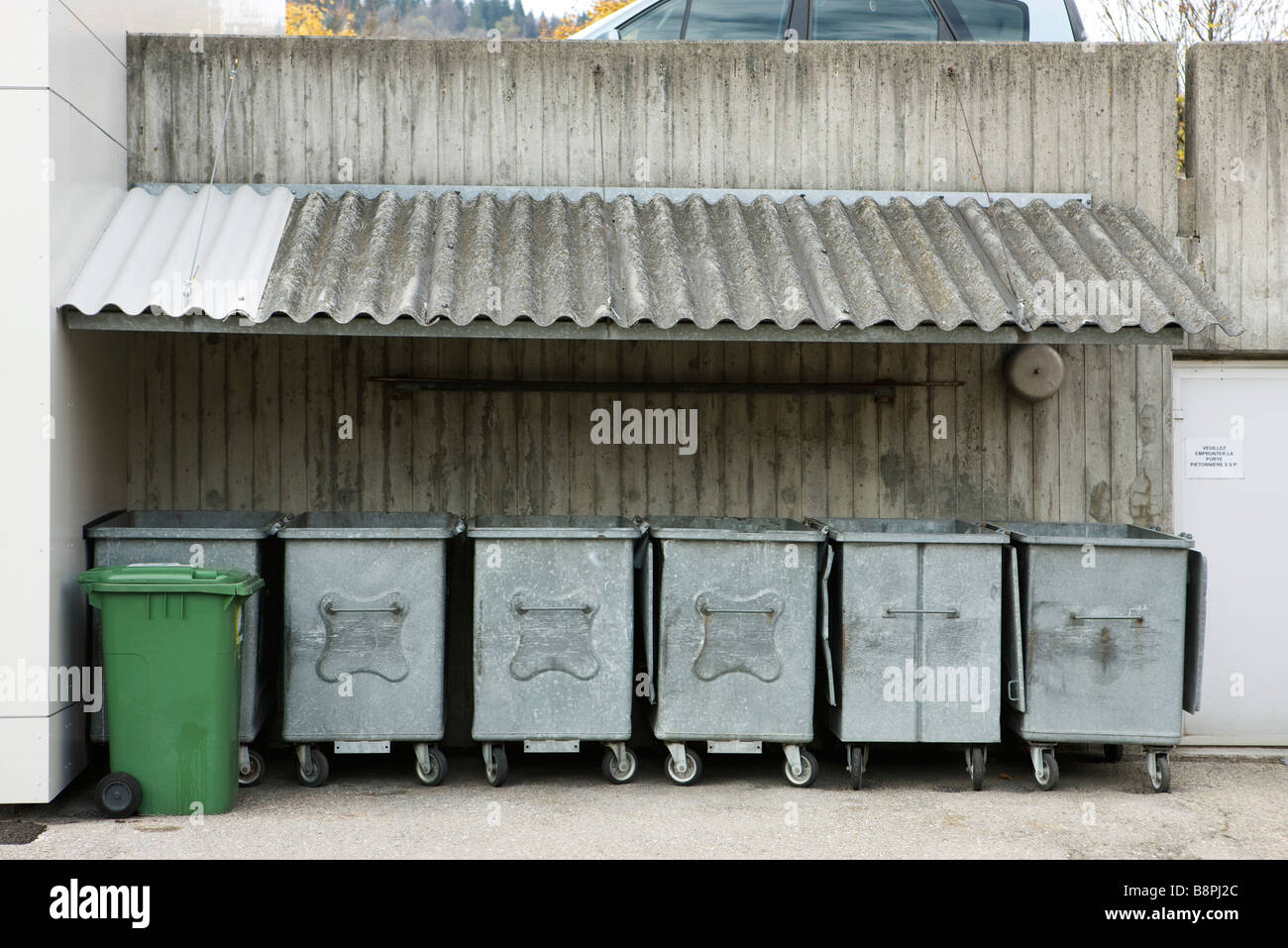 Trash bins lined up under awning Stock Photo
