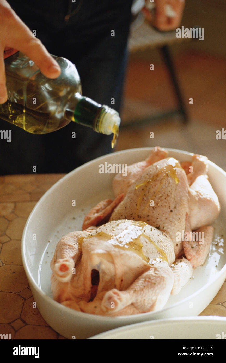 Drizzling olive oil on chickens Stock Photo Alamy