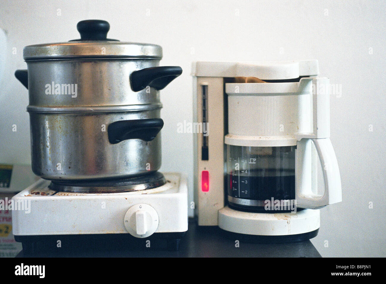 https://c8.alamy.com/comp/B8PJN1/steamer-on-hotplate-next-to-coffee-maker-on-counter-B8PJN1.jpg