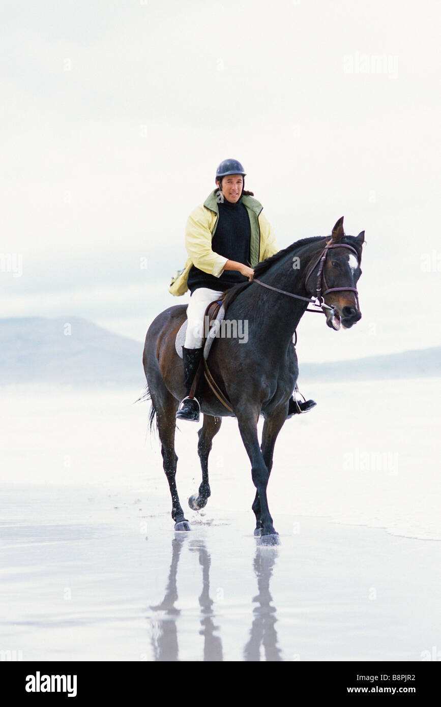Man riding horse on beach Stock Photo - Alamy