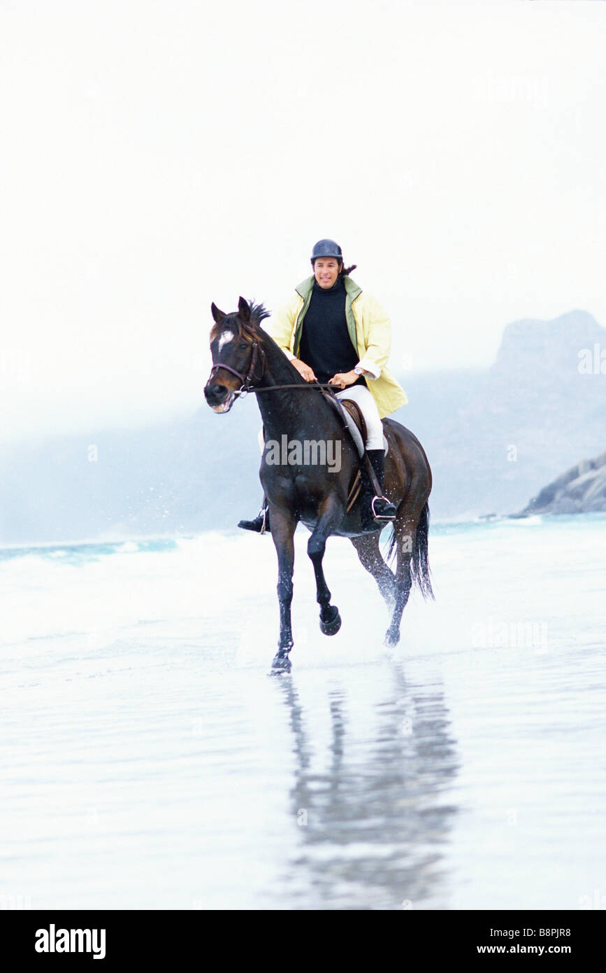 Man riding horse on beach Stock Photo - Alamy