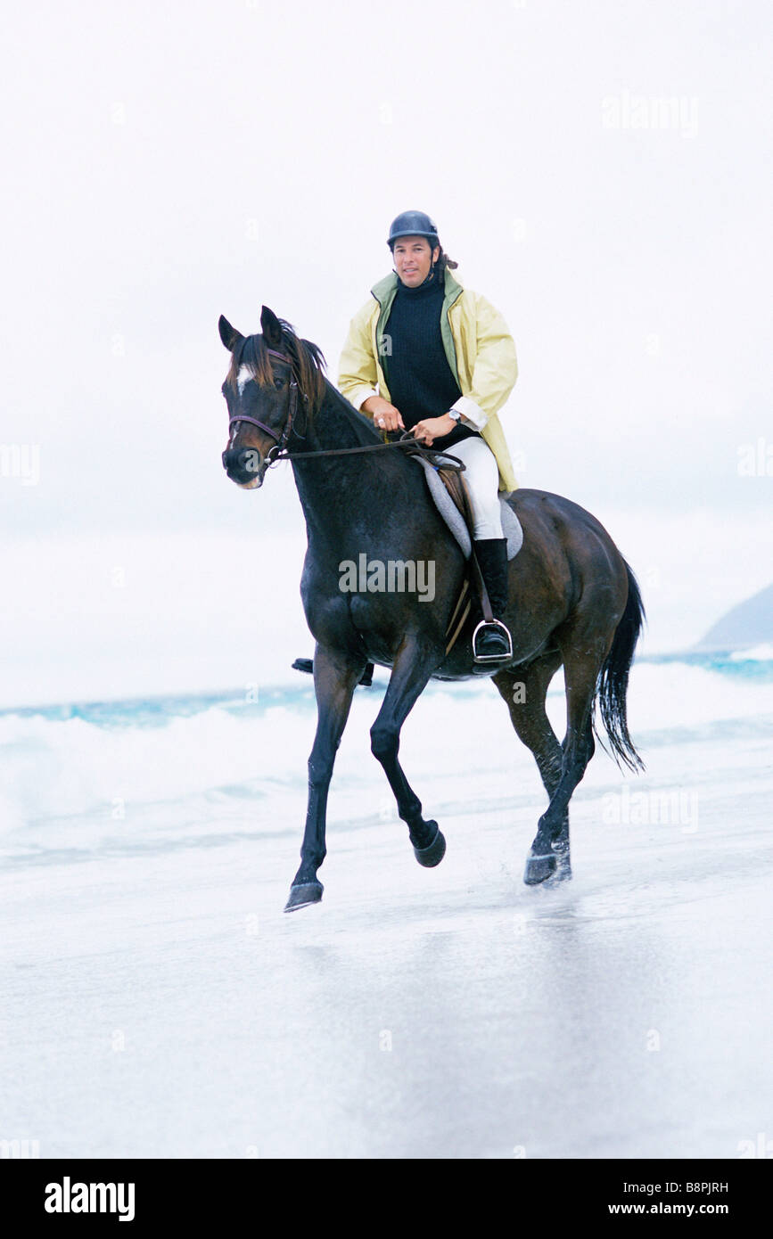 Man riding horse on beach Stock Photo - Alamy