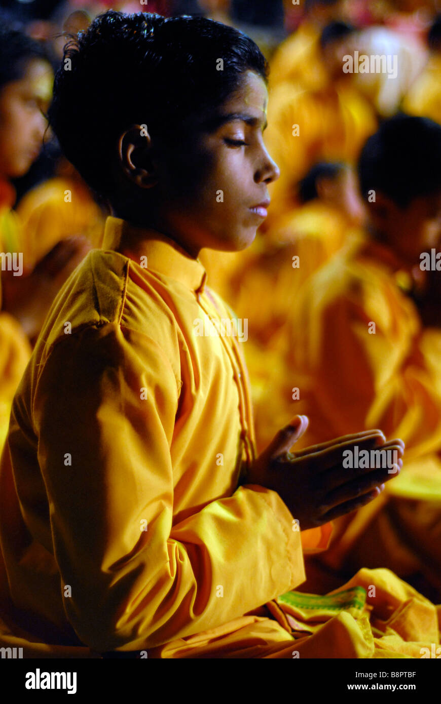 A boy with his hands held in prayer during the Ganga Aarti. Rishikesh, Uttaranchal, India Stock Photo