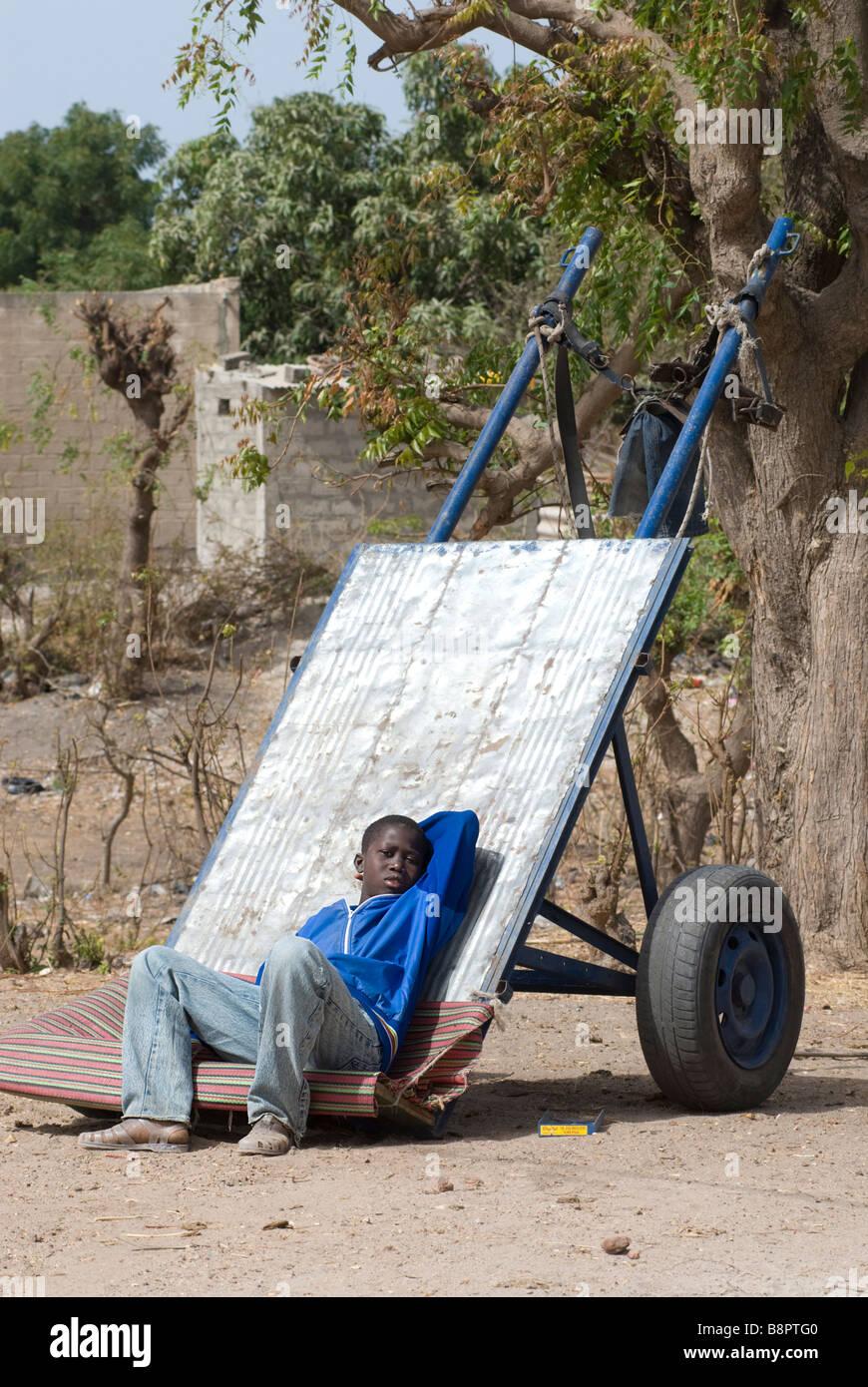 Young boy resting on his cart Senegal Stock Photo