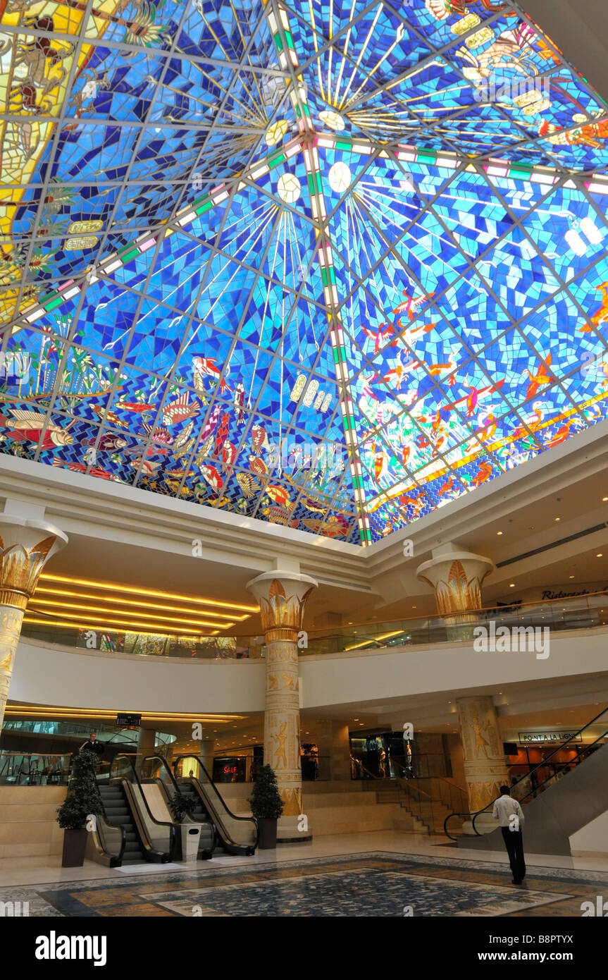 Dubai Wafi shopping mall interior with Egyptian pyramid style stained glass roof above escalator hall Stock Photo