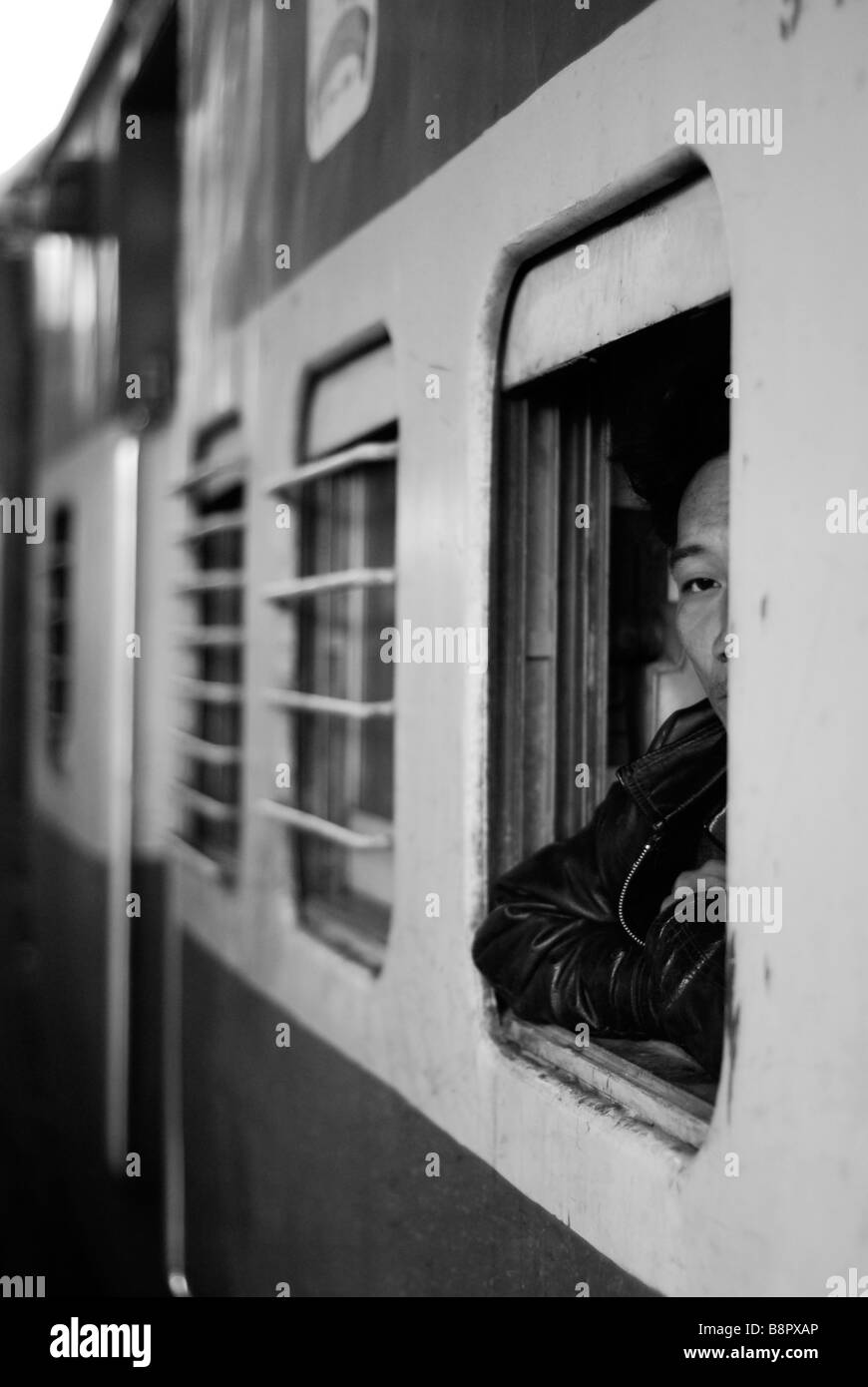 Indian man looking out of a train window, India Stock Photo