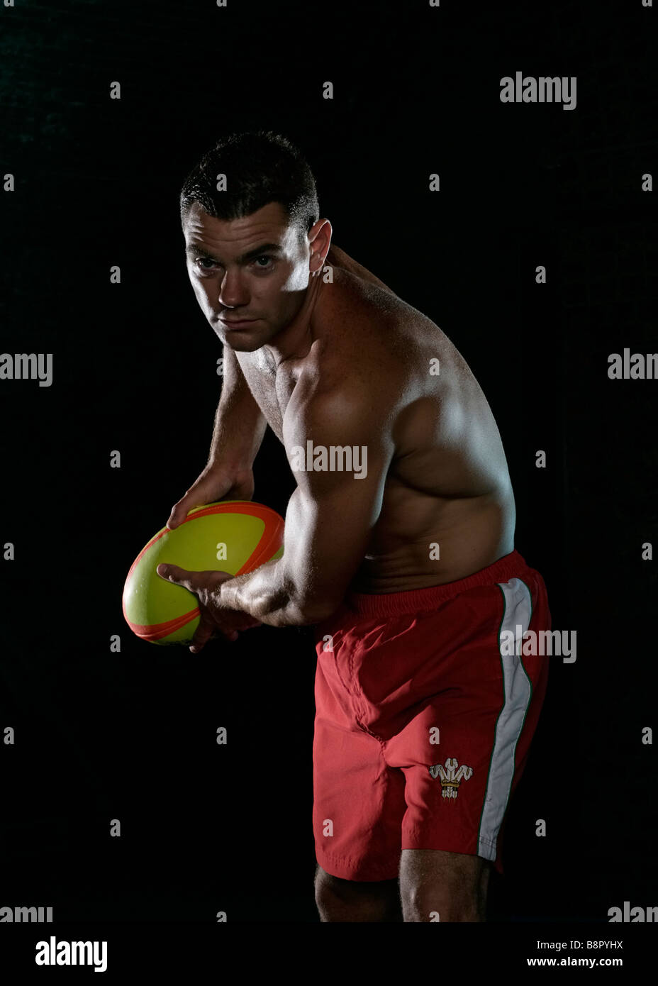 Rugby player night time,Train,Training, Power, Event, Sport, Horizontal, Rugby, Rugby League, Ball throwing, strength, night red Stock Photo