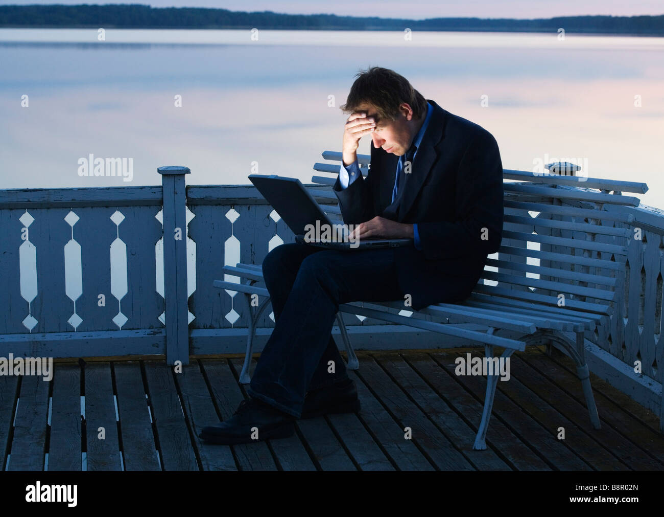 Depressed businessman in front of a laptop. Stock Photo