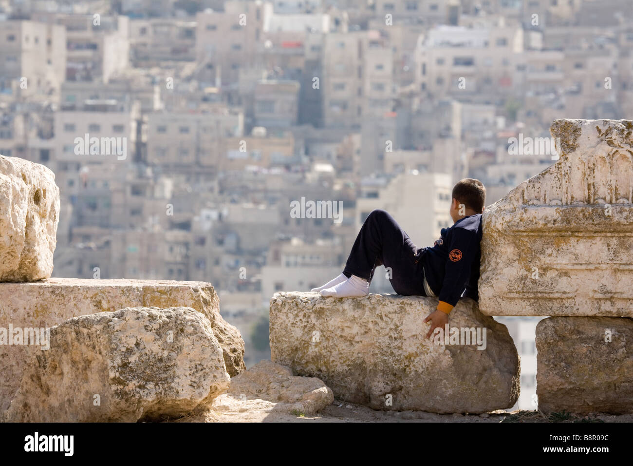 A young Jordanian boy child looking out over the city, The Citadel, Amman, Jordan, MIddle East Stock Photo