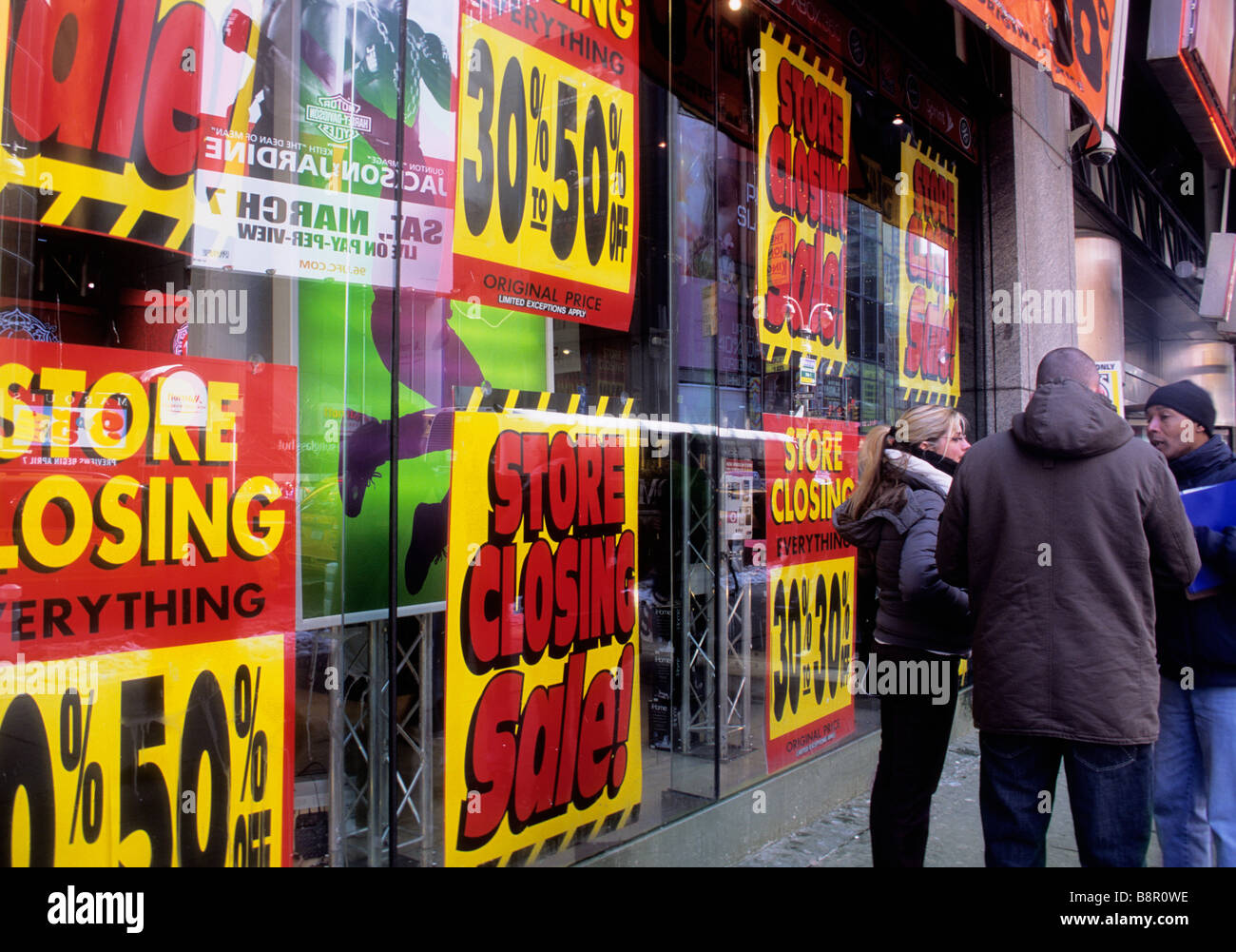 New York City Broadway and Times Square store closed, going out of business liquidation sale. Economic downturn. People standing on the street talking Stock Photo