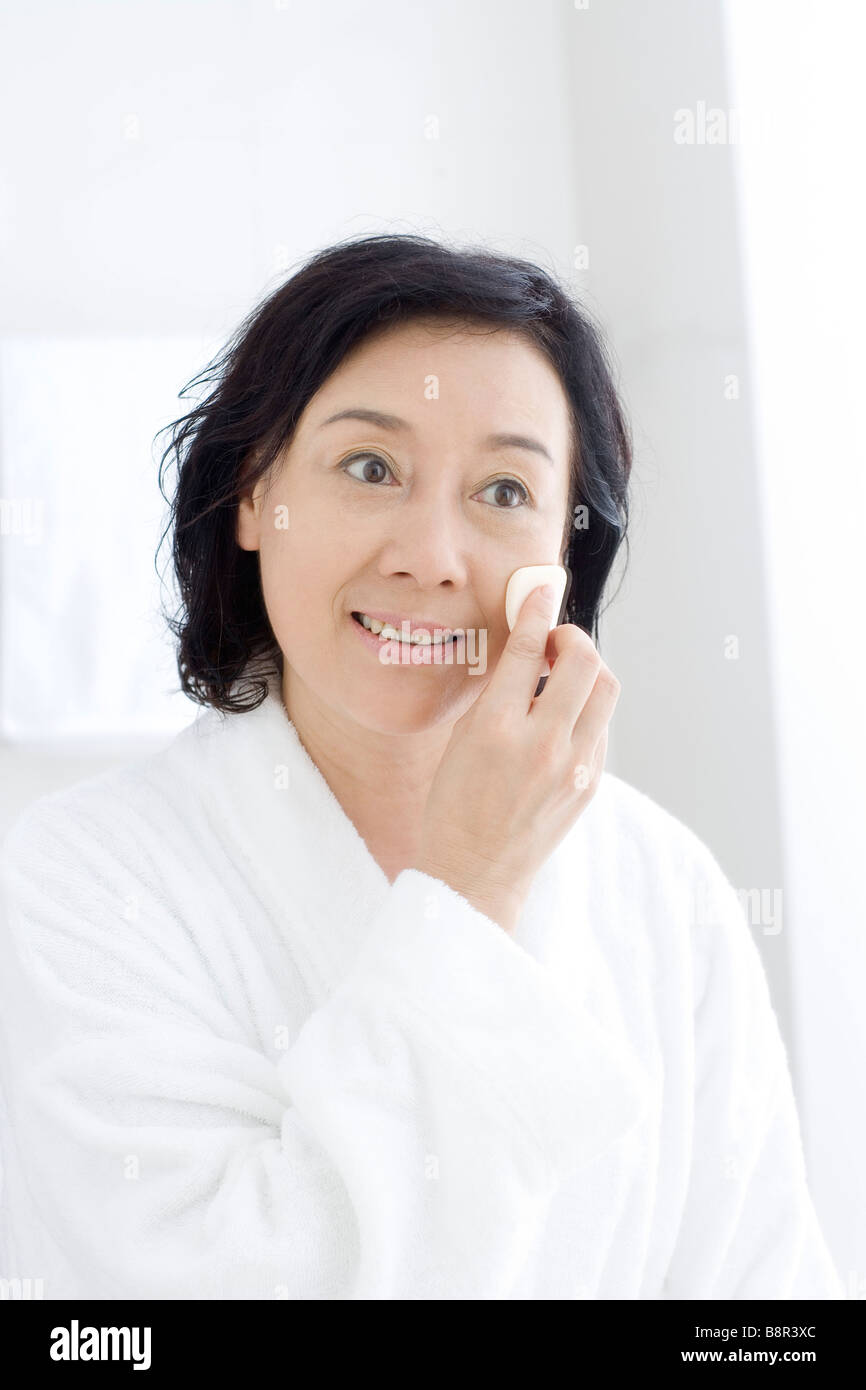 Senior woman using cotton pad on face Stock Photo Alamy