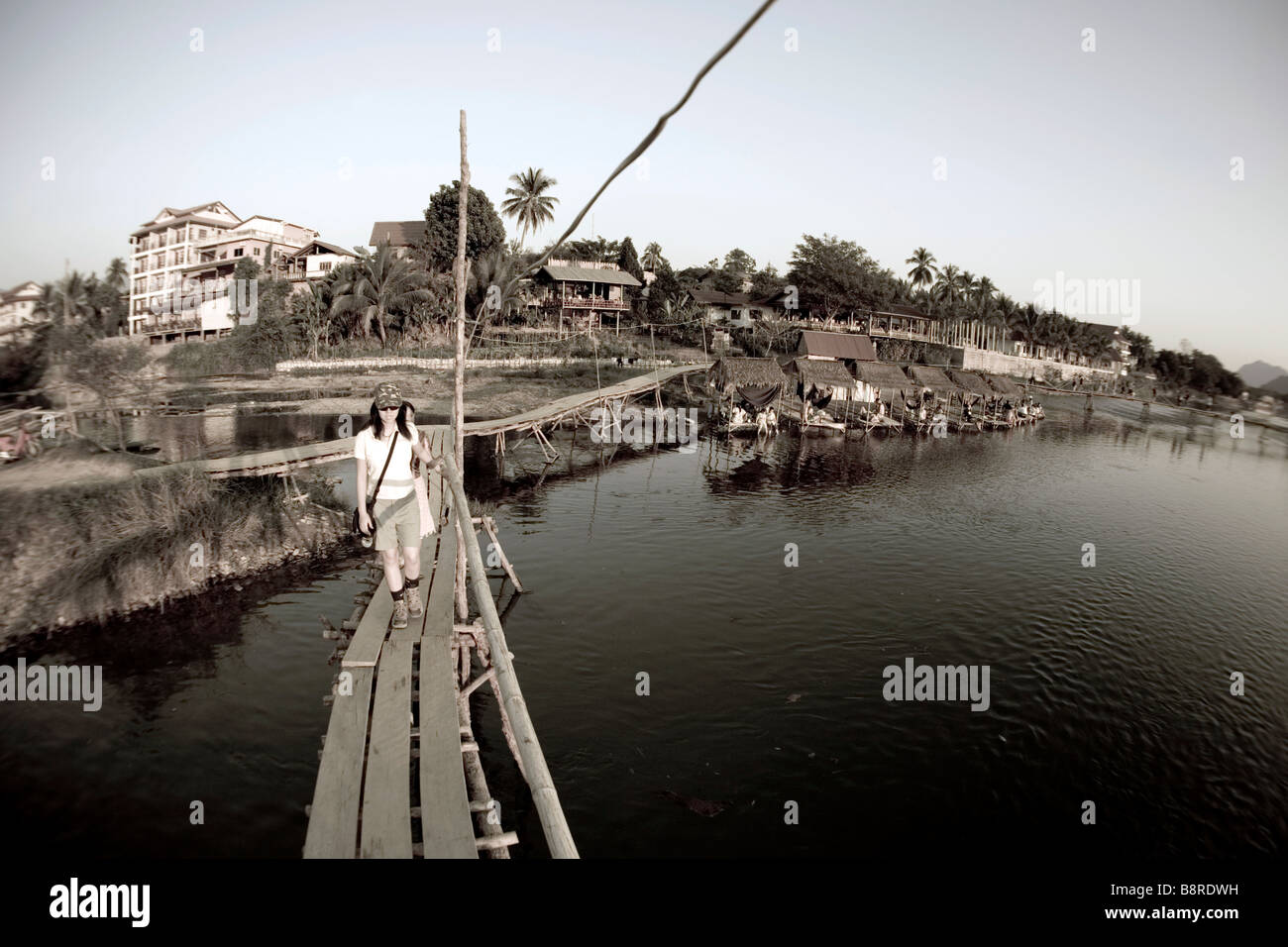 Laos, Vientiane Province, Vang Vieng, Nam Song River, bridges, woman, tourists, huts. Stock Photo