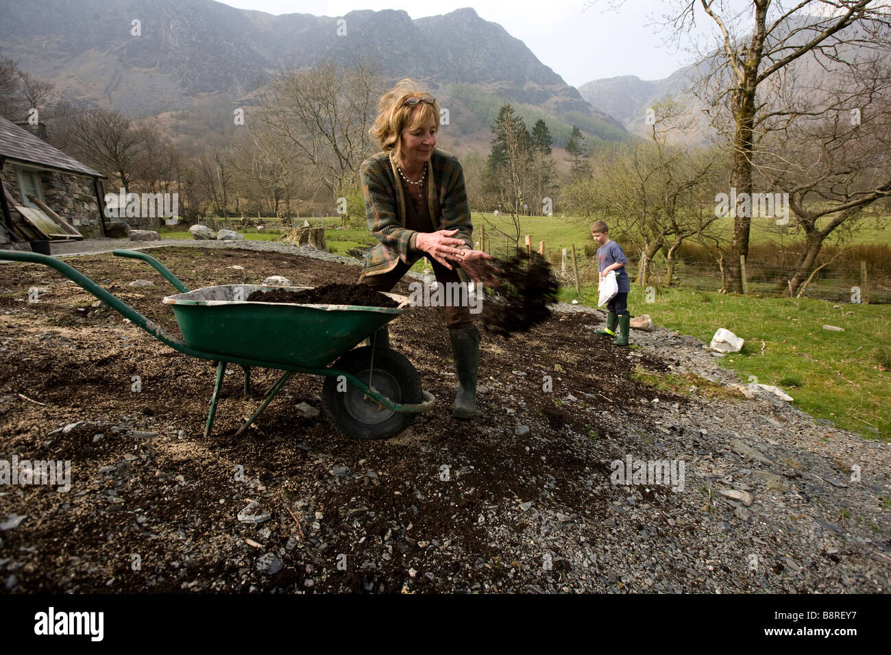 Woman and child Preparing garden remote cottage near Machynlleth Snowdonia Gwynedd North Wales Stock Photo