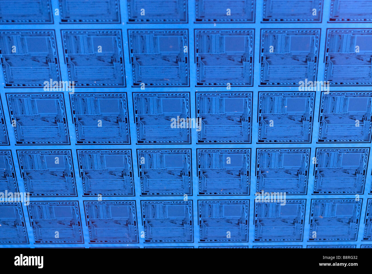Pattern of microchip circuits on silicon semiconductor computer wafer. Stock Photo