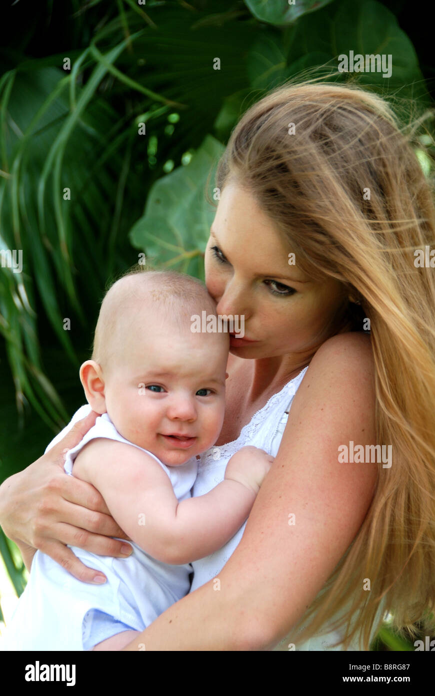 Young mother kissing and holding baby Stock Photo
