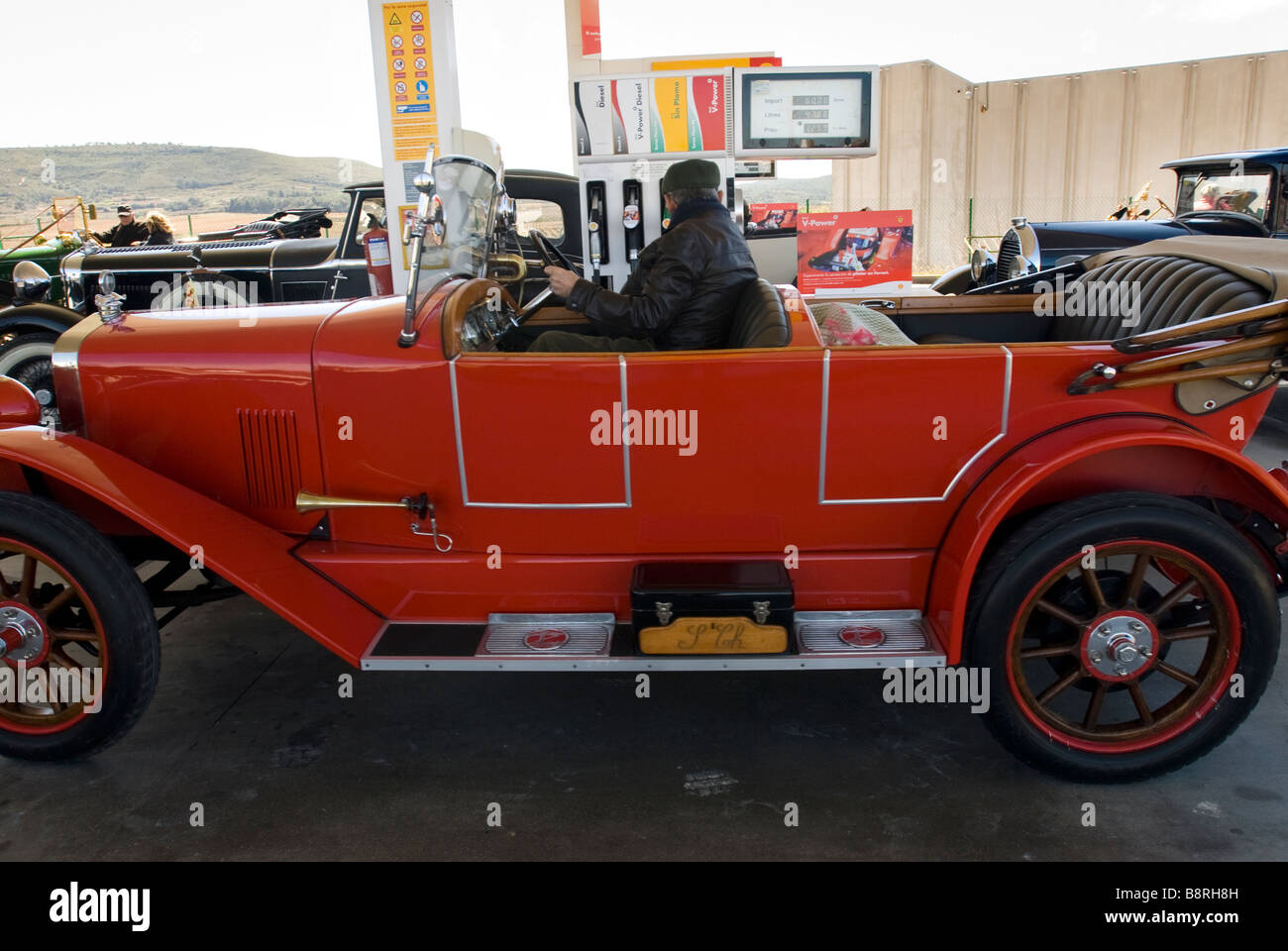 Group of old cars filling up their gas tanks in a petrol station Stock