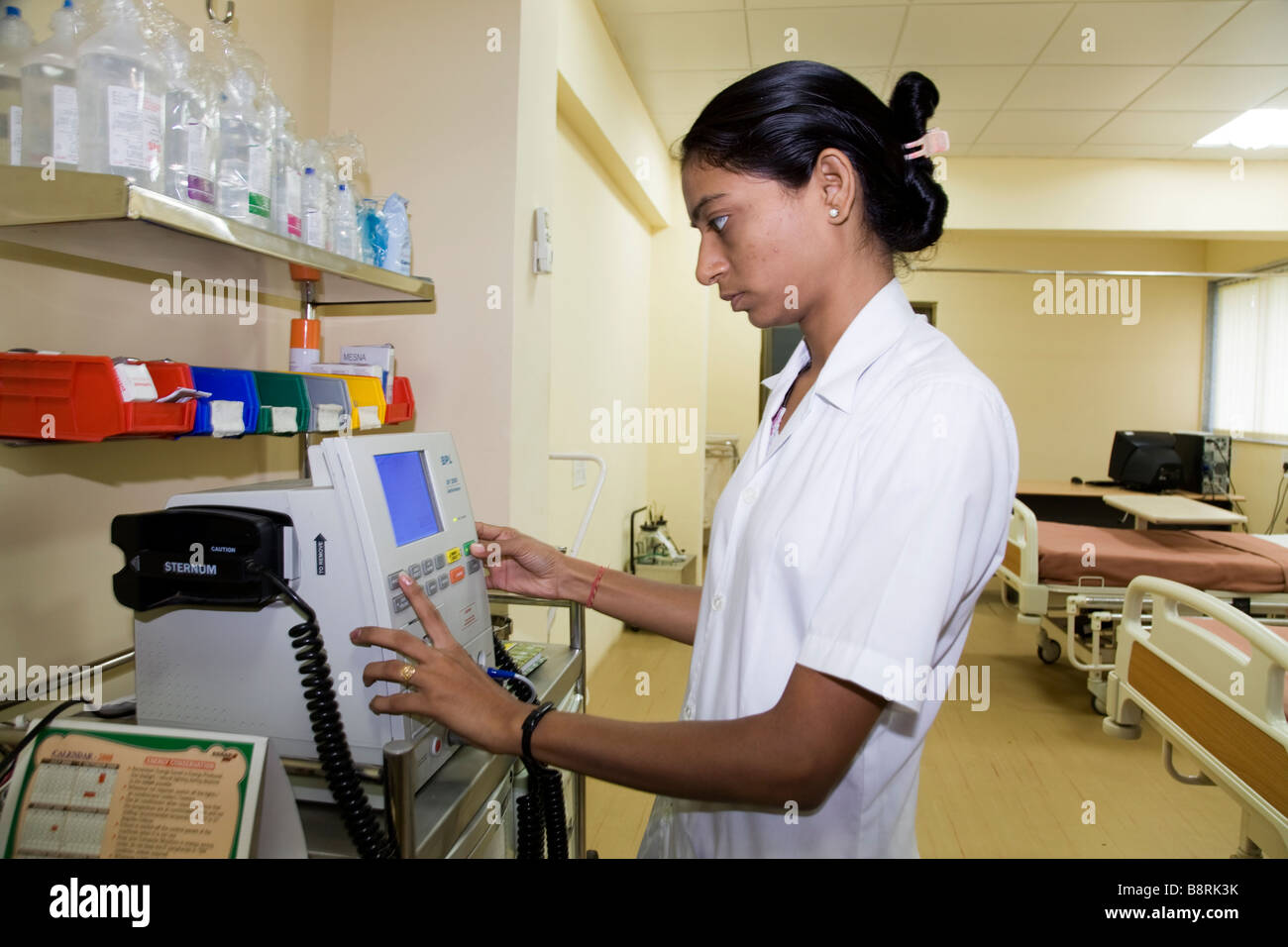 Indian nurse checking a defibrillator machine ( for restoring regular