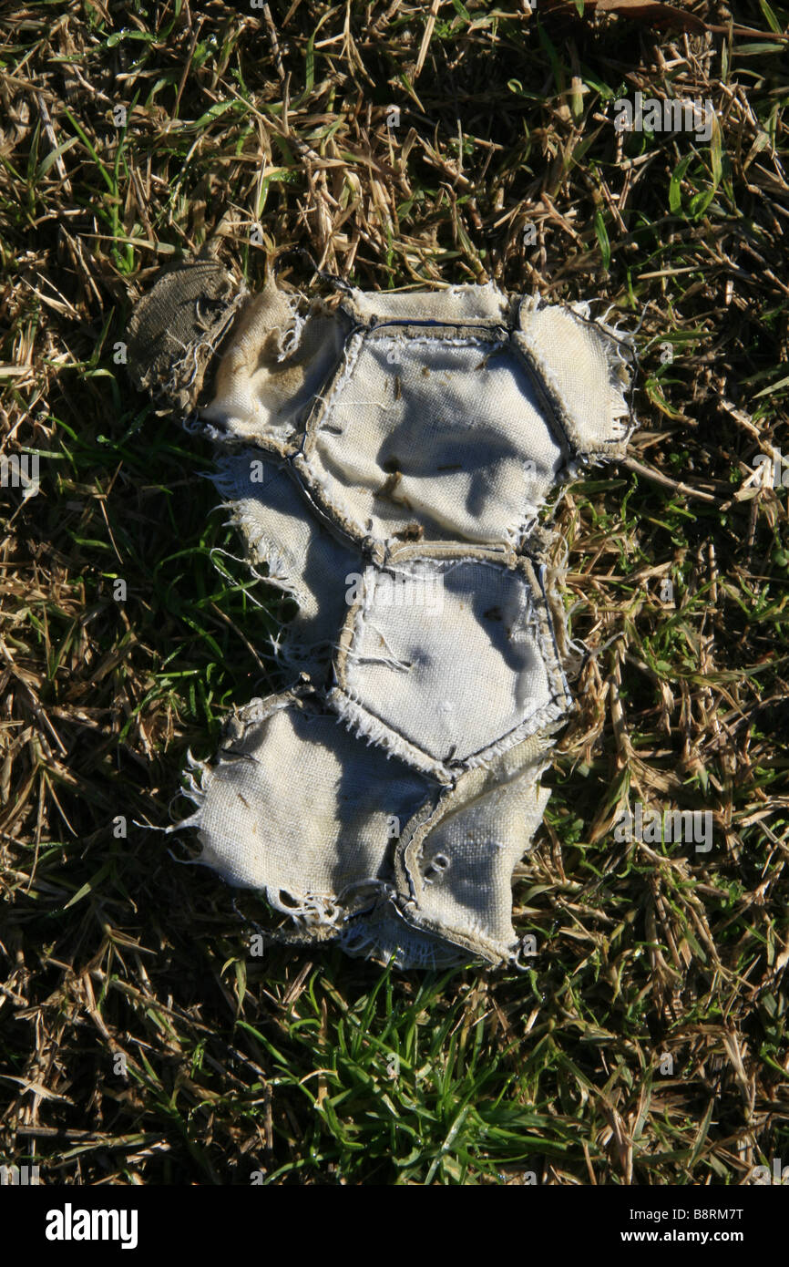 Damaged Football part of one old damaged leather football in field Stock Photo - Alamy