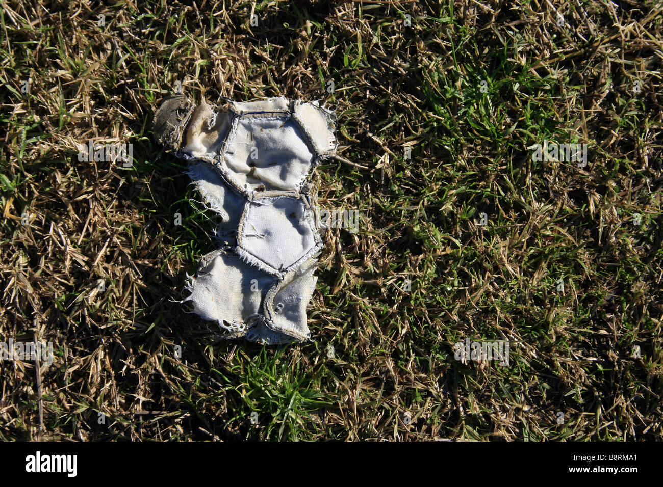 Damaged Football part of one old damaged leather football in field Stock Photo - Alamy
