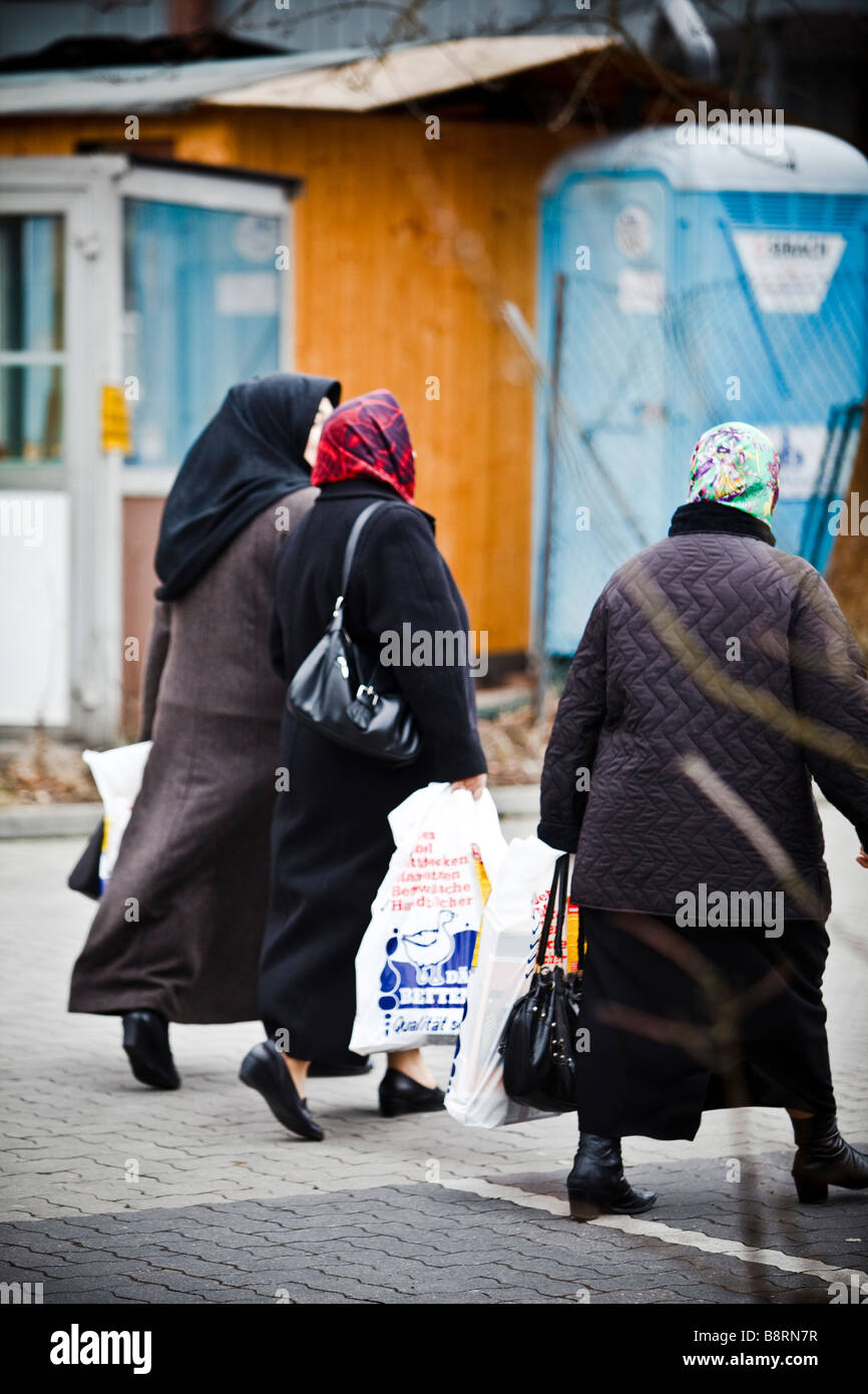 Group of muslem women wearing scarf crossing a street with plastic bags after shopping in Hamburg, Germany Stock Photo